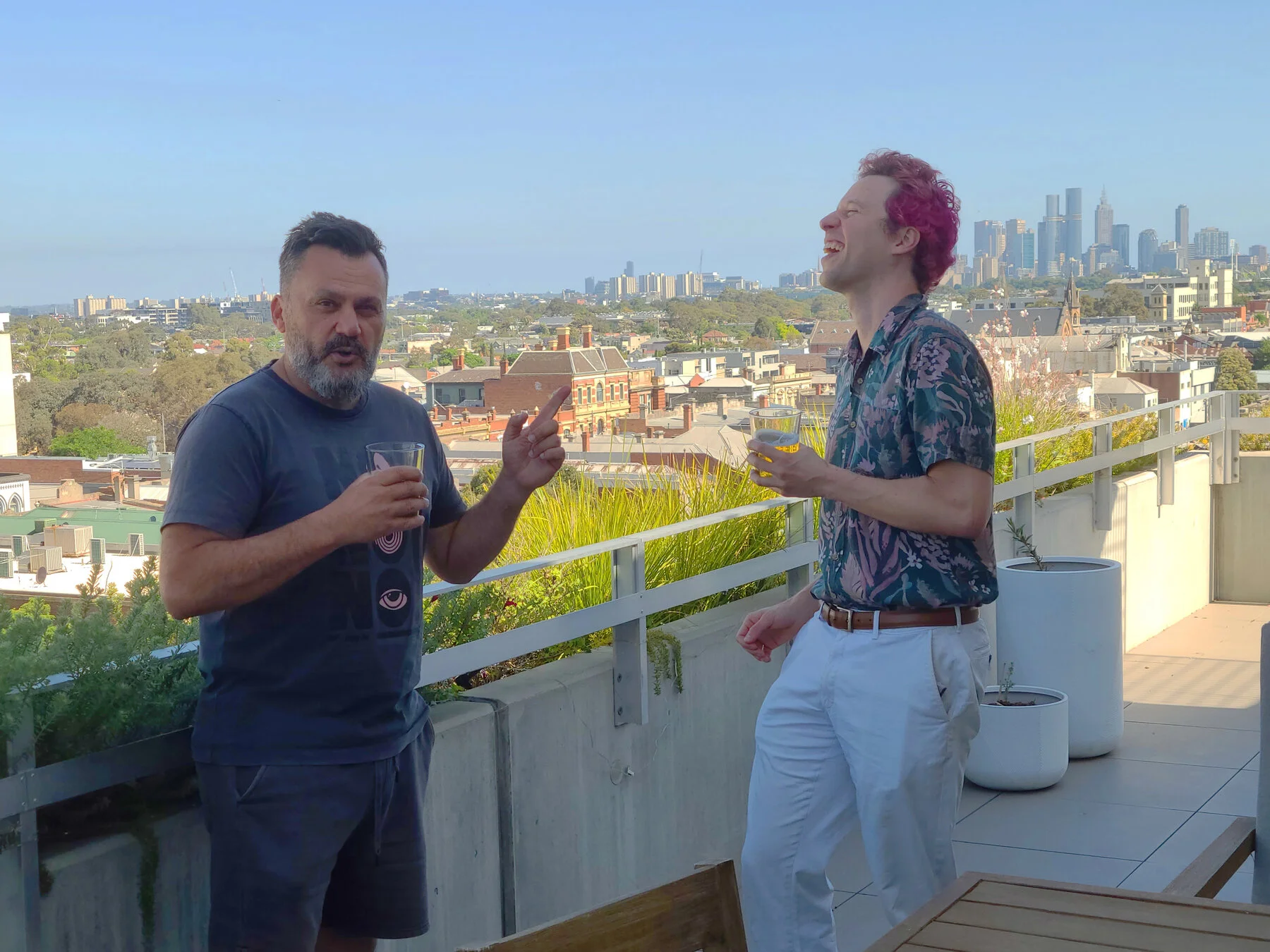 Two raconteurs laughing with Melbourne skyline panorama